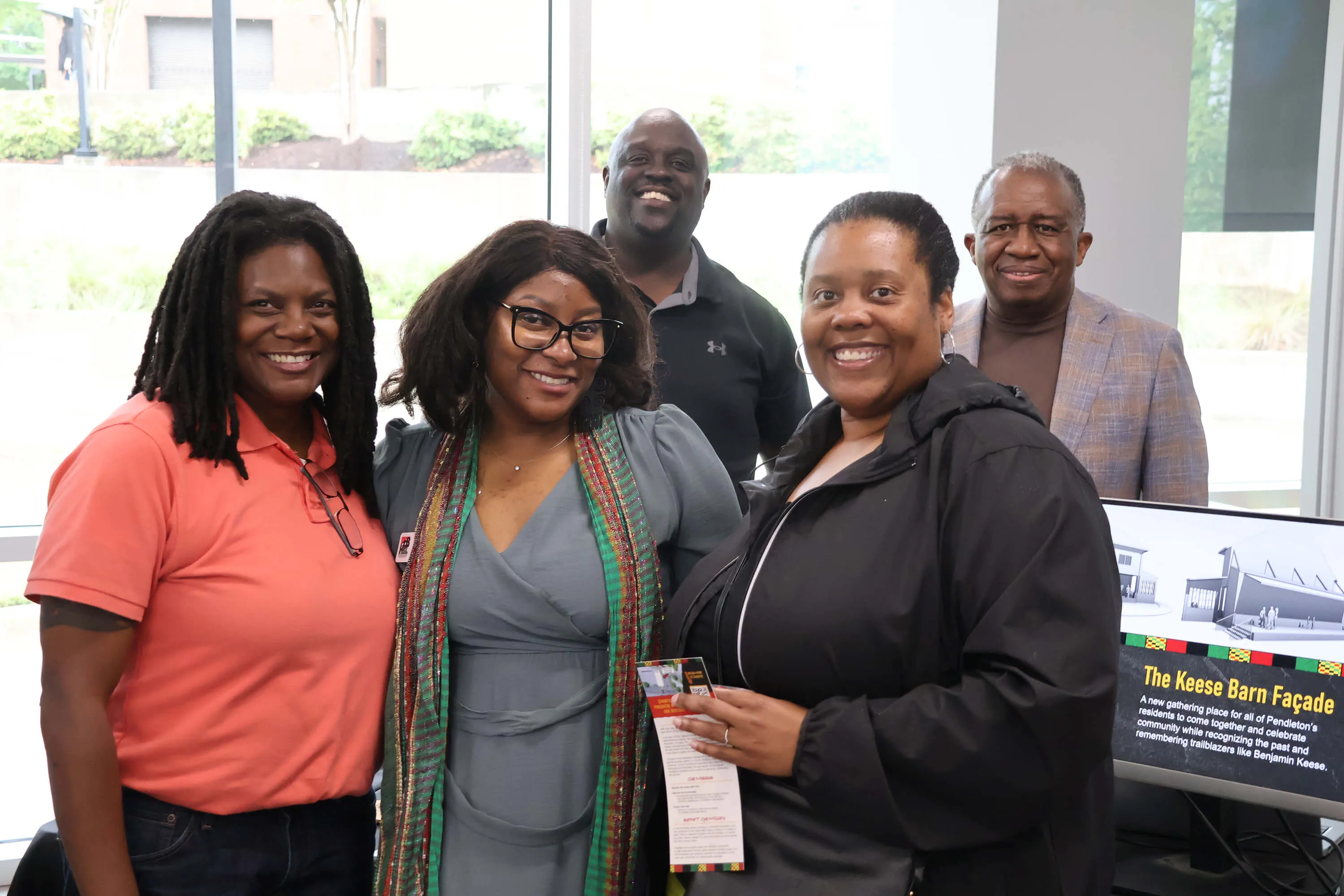 A family next to a Keese Barn Facade sign