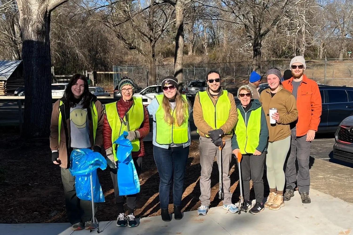A group of people in high visual vests cleaning up town